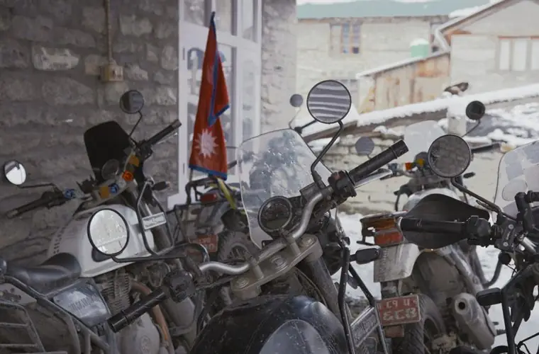 Bikes and a Nepal flag in a mountain village